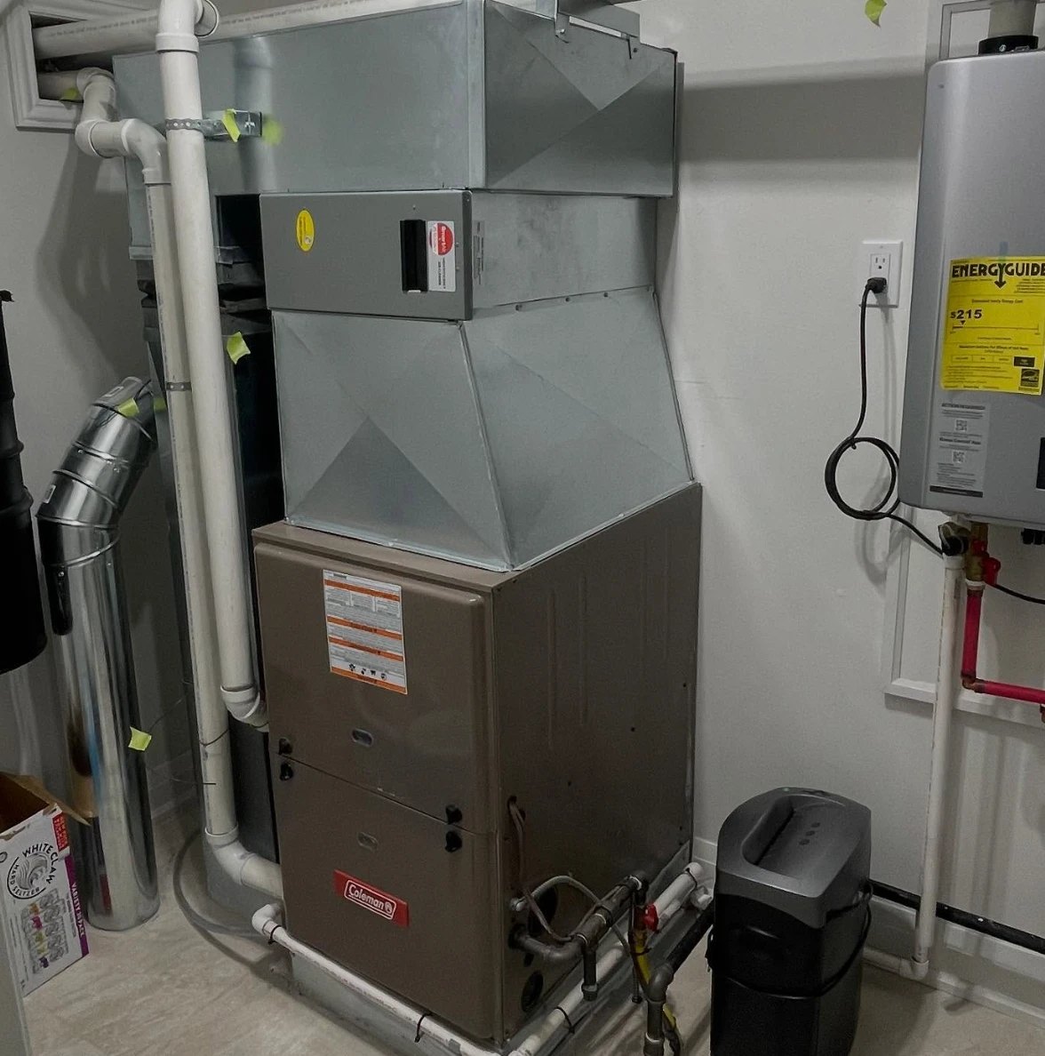 Coleman furnace and new ductwork installed by Alpha Home Comfort, beside a tankless water heater